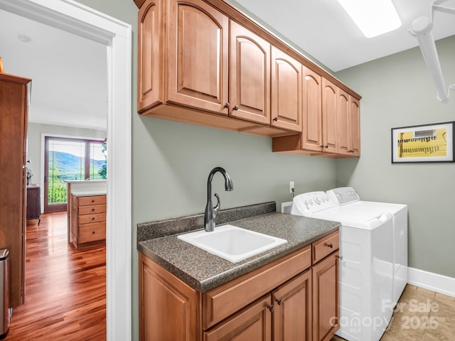 556 High Pines Loop, Lake Lure, NC 28746 - laundry area featuring cabinet space, washing machine and dryer, baseboards, and light wood finished floors