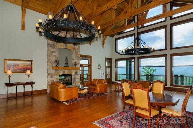 556 High Pines Loop, Lake Lure, NC 28746 - dining area with a chandelier, high vaulted ceiling, wood finished floors, a stone fireplace, and wood ceiling with exposed beams