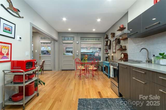 107 Cherry St, Black Mountain, NC 28711 - kitchen with tasteful backsplash, light countertops, open shelves, light wood-style floors, and modern cabinets
