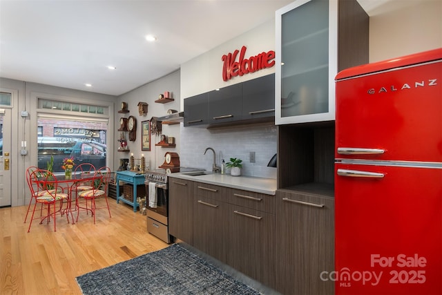 107 Cherry St, Black Mountain, NC 28711 - kitchen with backsplash, freestanding refrigerator, light wood-style floors, stainless steel range with electric cooktop, and a sink