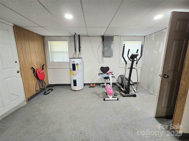 workout area with electric panel, electric water heater, a wealth of natural light, and a drop ceiling