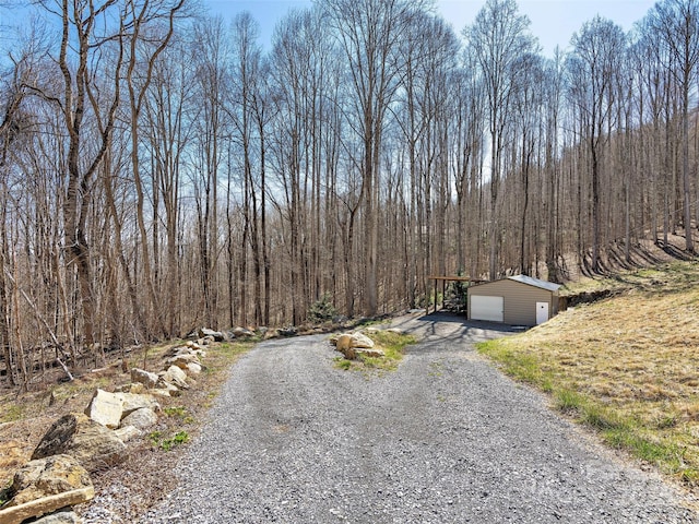 view of street featuring driveway and a wooded view