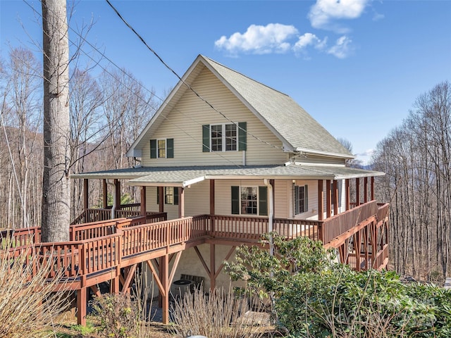rear view of house with roof with shingles