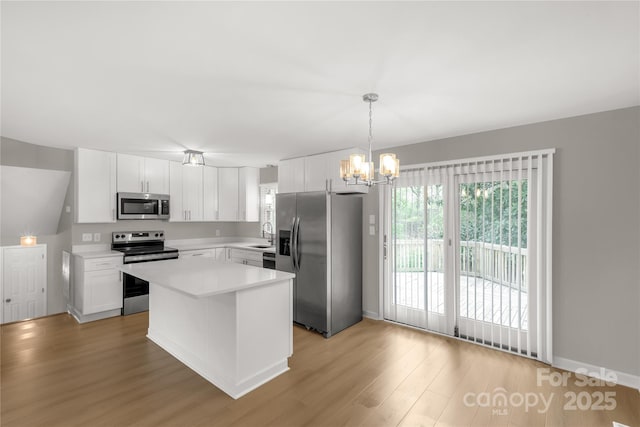 kitchen with a notable chandelier, light wood-style flooring, light countertops, white cabinetry, and appliances with stainless steel finishes