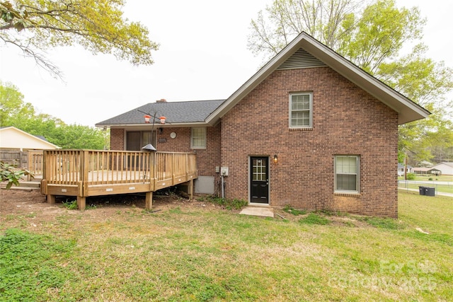 rear view of house featuring a lawn, a deck, and brick siding