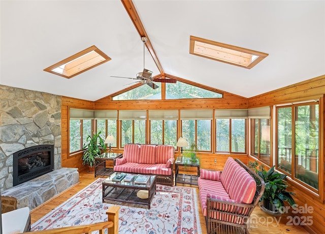 1192 Rockdale Rd, Whittier, NC 28789 - living area featuring vaulted ceiling with skylight, a ceiling fan, a fireplace, wood walls, and wood finished floors