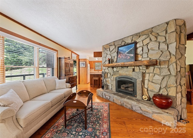 1192 Rockdale Rd, Whittier, NC 28789 - living area with ornamental molding, a stone fireplace, a textured ceiling, and wood finished floors