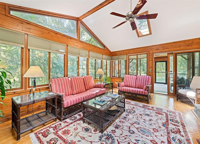 1192 Rockdale Rd, Whittier, NC 28789 - living room featuring wood-type flooring, wooden walls, ceiling fan, and vaulted ceiling with skylight