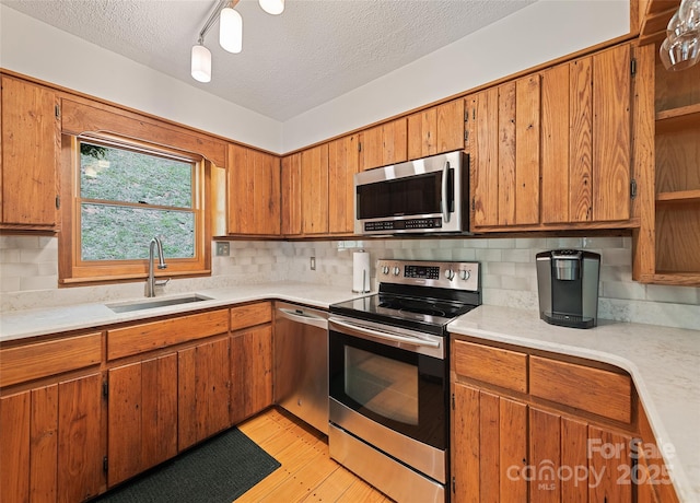 1192 Rockdale Rd, Whittier, NC 28789 - kitchen featuring brown cabinetry, decorative backsplash, light countertops, a sink, and stainless steel appliances