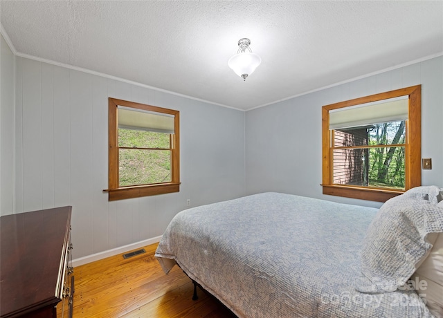 1192 Rockdale Rd, Whittier, NC 28789 - bedroom with multiple windows, ornamental molding, wood finished floors, and visible vents