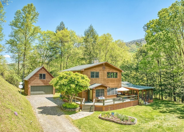 1192 Rockdale Rd, Whittier, NC 28789 - view of front of home with a chimney, a garage, a wooded view, an outdoor structure, and a front lawn