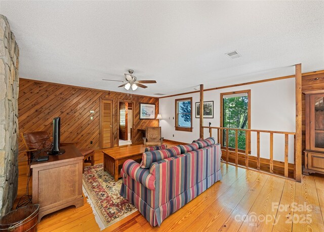 1192 Rockdale Rd, Whittier, NC 28789 - living area featuring ceiling fan, visible vents, wood walls, light wood-style floors, and ornamental molding