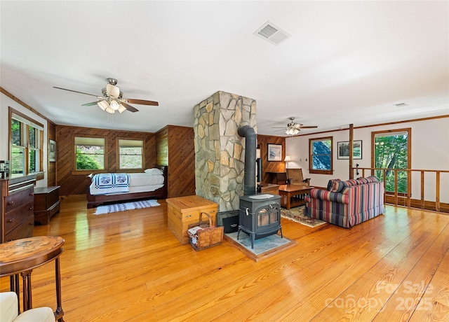 1192 Rockdale Rd, Whittier, NC 28789 - living area featuring a ceiling fan, ornamental molding, a wood stove, and light wood-style floors