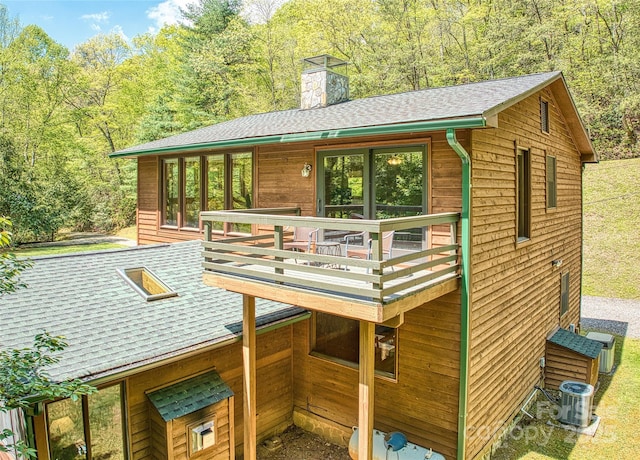 1192 Rockdale Rd, Whittier, NC 28789 - rear view of property featuring central AC, a deck, roof with shingles, a chimney, and a forest view