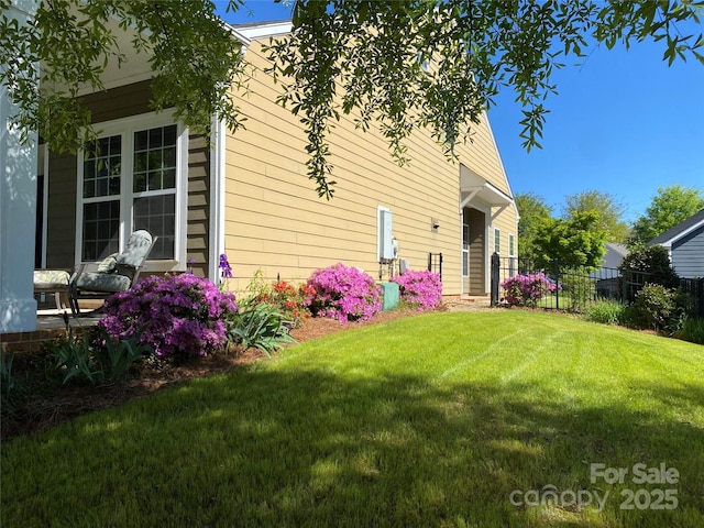 rear view of house with fence and a yard