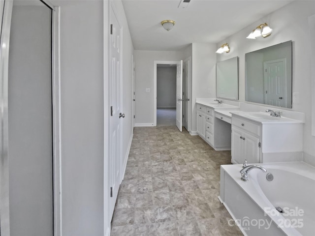 full bath with double vanity, a sink, baseboards, and a bath
