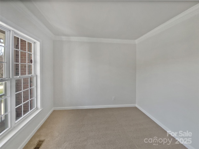 empty room featuring baseboards, visible vents, ornamental molding, and carpet flooring
