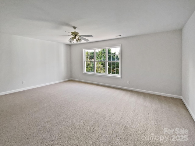 unfurnished room with carpet flooring, a ceiling fan, and baseboards
