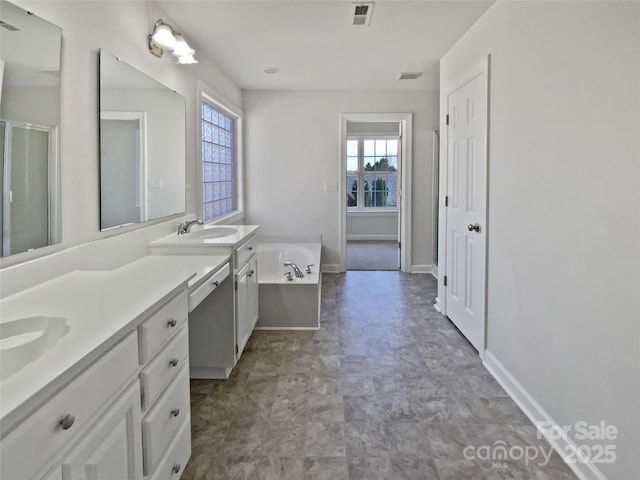 full bathroom with a sink, a healthy amount of sunlight, a garden tub, and visible vents