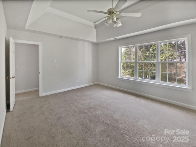 unfurnished room featuring a ceiling fan, carpet floors, baseboards, and a raised ceiling
