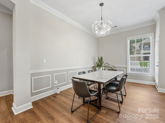 4148 Cedar Point Ave, Matthews, NC 28104 - dining space with ornamental molding, a chandelier, and wood finished floors