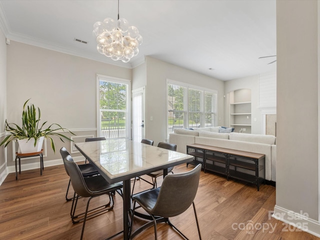 4148 Cedar Point Ave, Matthews, NC 28104 - dining space featuring a chandelier, wood finished floors, crown molding, and built in features