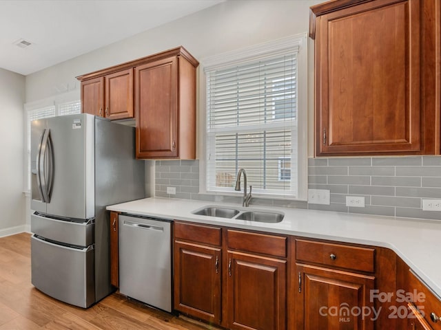 4148 Cedar Point Ave, Matthews, NC 28104 - kitchen with appliances with stainless steel finishes, light wood finished floors, light countertops, decorative backsplash, and brown cabinets
