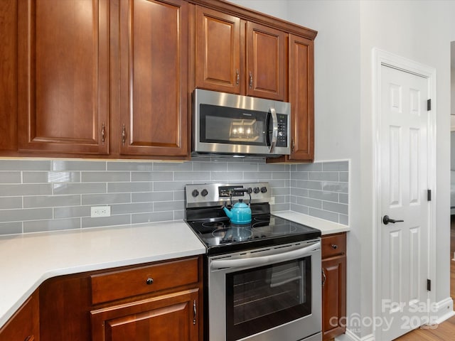 4148 Cedar Point Ave, Matthews, NC 28104 - kitchen with stainless steel appliances, light countertops, backsplash, and brown cabinets