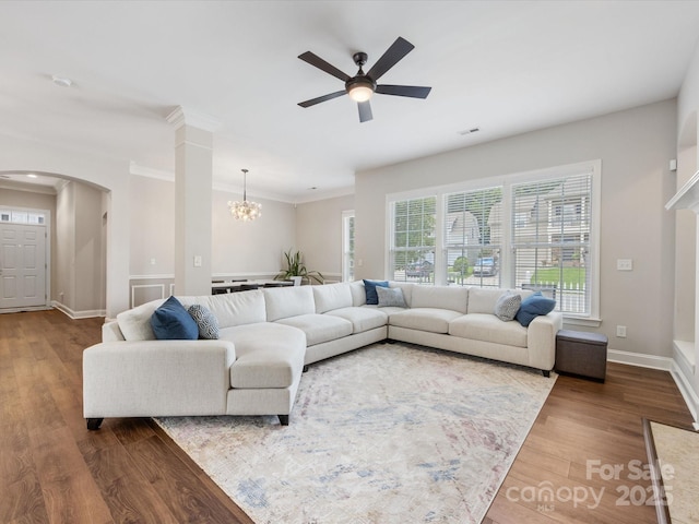 4148 Cedar Point Ave, Matthews, NC 28104 - living room with arched walkways, ceiling fan, wood finished floors, a chandelier, and crown molding