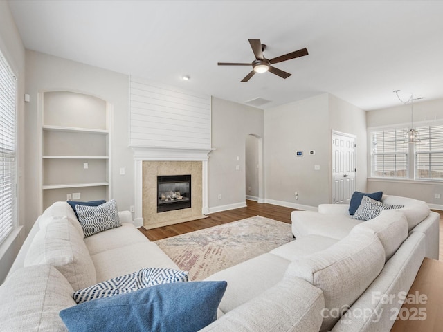 4148 Cedar Point Ave, Matthews, NC 28104 - living area featuring ceiling fan, arched walkways, wood finished floors, a premium fireplace, and built in shelves