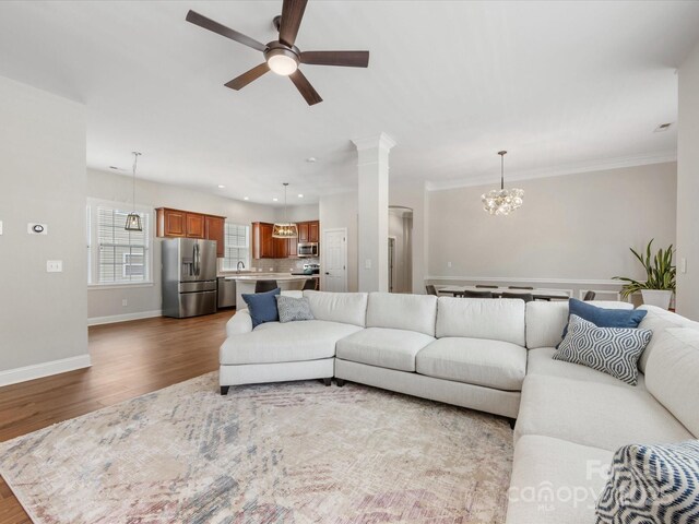 4148 Cedar Point Ave, Matthews, NC 28104 - living room featuring wood finished floors, a chandelier, a ceiling fan, recessed lighting, and crown molding