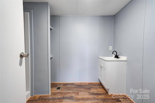 bathroom with visible vents, wood finished floors, and vanity
