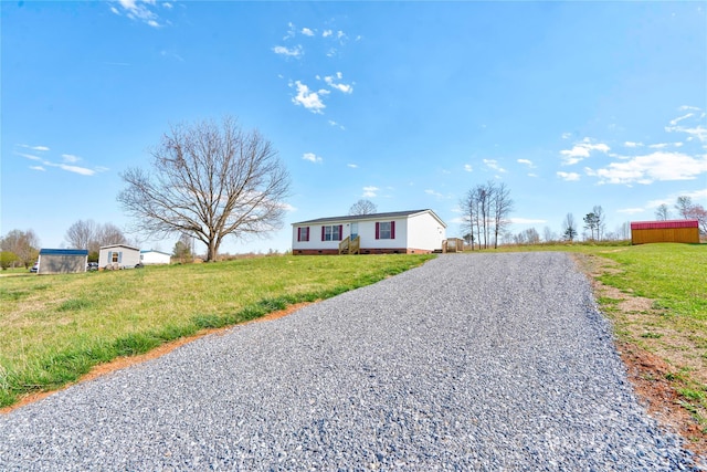 view of front of house with a front lawn, crawl space, and gravel driveway