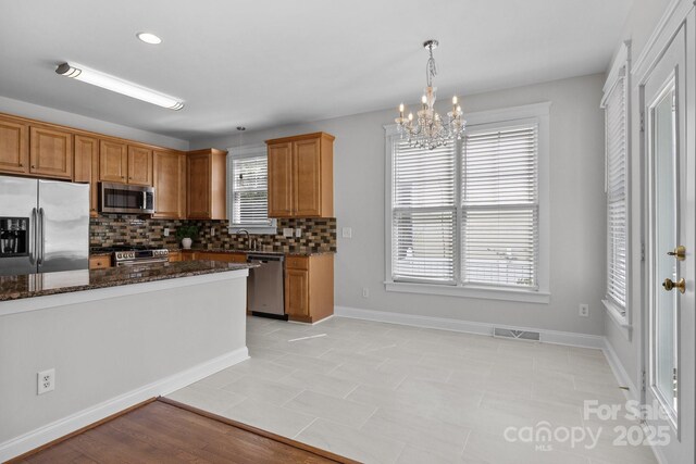 9652 Alma Blount Blvd, Charlotte, NC 28277 - kitchen with tasteful backsplash, a sink, an inviting chandelier, appliances with stainless steel finishes, and visible vents