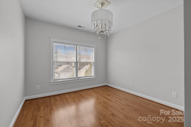 9652 Alma Blount Blvd, Charlotte, NC 28277 - empty room with a chandelier, wood finished floors, visible vents, and baseboards