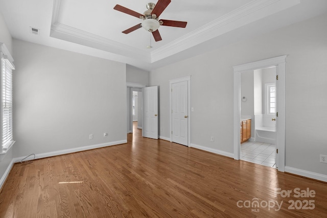 9652 Alma Blount Blvd, Charlotte, NC 28277 - unfurnished bedroom featuring baseboards, ornamental molding, a tray ceiling, and light wood-type flooring