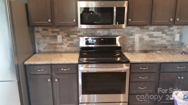 119 Tryon View Dr, Flat Rock, NC 28731 - kitchen featuring appliances with stainless steel finishes, backsplash, dark brown cabinets, and light stone counters