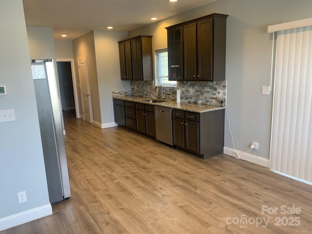 119 Tryon View Dr, Flat Rock, NC 28731 - kitchen featuring stainless steel appliances, baseboards, a sink, dark brown cabinets, and decorative backsplash