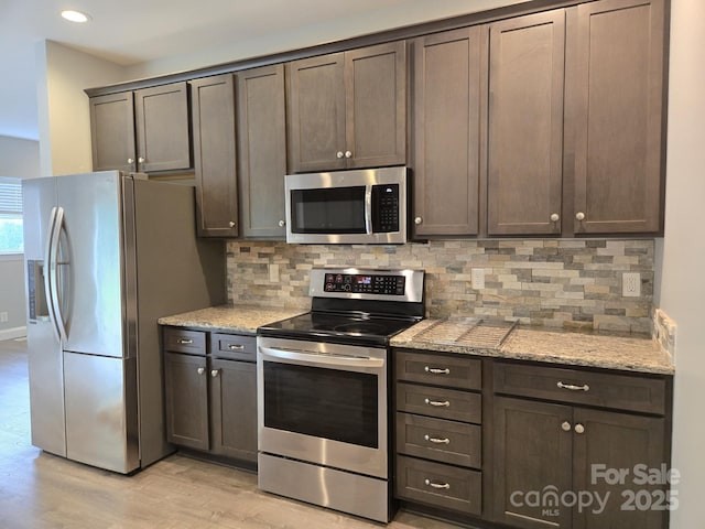 119 Tryon View Dr, Flat Rock, NC 28731 - kitchen featuring appliances with stainless steel finishes, light wood-type flooring, tasteful backsplash, light stone countertops, and recessed lighting