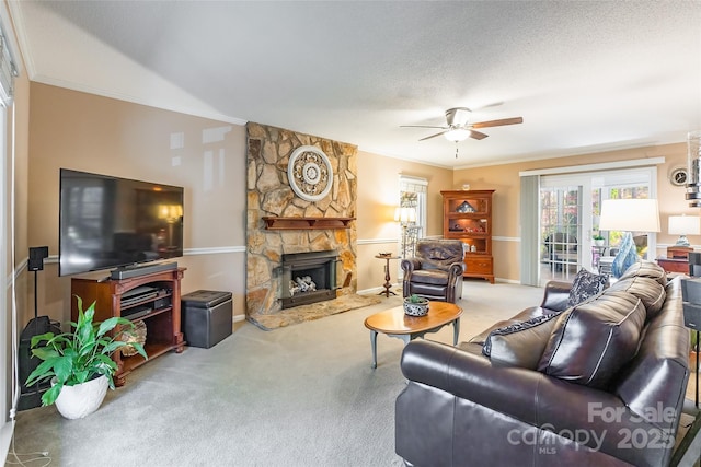 10028 Bora Bora Dr, Tega Cay, SC 29708 - carpeted living room with a textured ceiling, baseboards, ornamental molding, a ceiling fan, and a stone fireplace