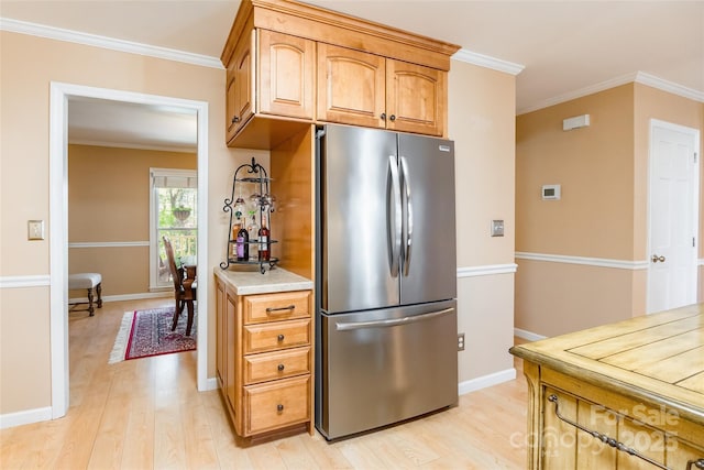 10028 Bora Bora Dr, Tega Cay, SC 29708 - kitchen with freestanding refrigerator, light countertops, ornamental molding, and light wood-type flooring