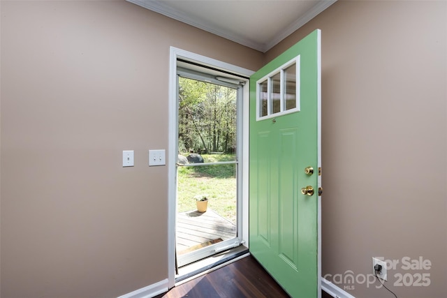 foyer with crown molding, baseboards, and dark wood-style flooring