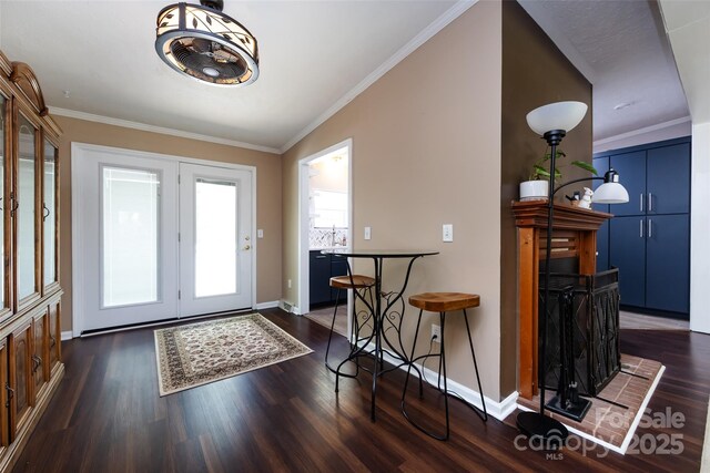 entryway with ornamental molding, baseboards, and dark wood-style floors