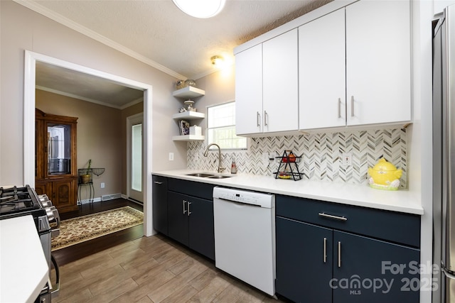 kitchen featuring open shelves, dishwasher, a sink, light countertops, and light wood-style flooring