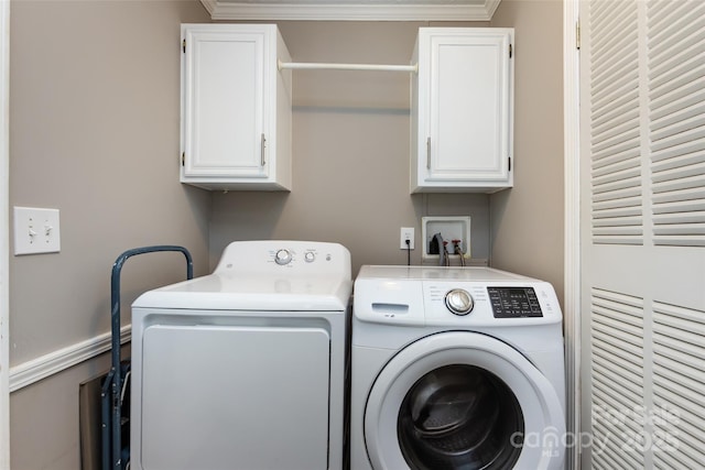 washroom featuring washer and dryer, ornamental molding, and cabinet space