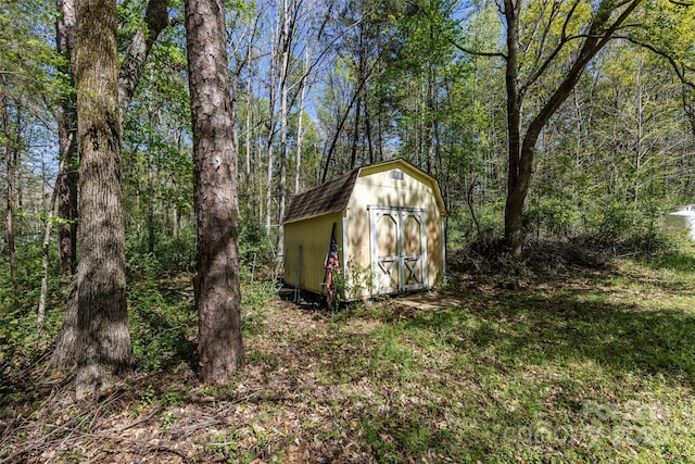 view of shed with a view of trees