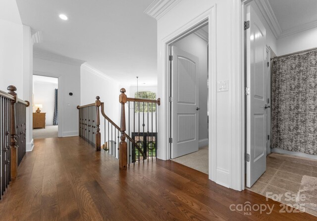 hall with ornamental molding, wood finished floors, baseboards, recessed lighting, and an upstairs landing