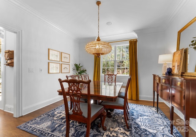 dining room featuring baseboards, ornamental molding, dark wood-style flooring, and a chandelier