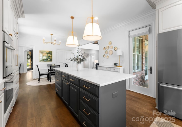 kitchen featuring crown molding, stainless steel appliances, dark wood finished floors, and white cabinetry