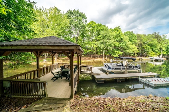 view of dock featuring a gazebo, a water view, and a view of trees